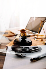 Justice and law concept.Male judge in a courtroom with the gavel, working with, computer and docking keyboard, eyeglasses, on table in morning light