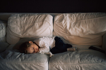 Jeune enfant fait sa sièste dans le canapé 