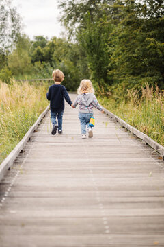 enfants marchent main dans la main lors d'une balade dans la nature au printemps