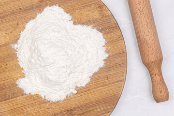 White Flour on the wooden board with rolling pin