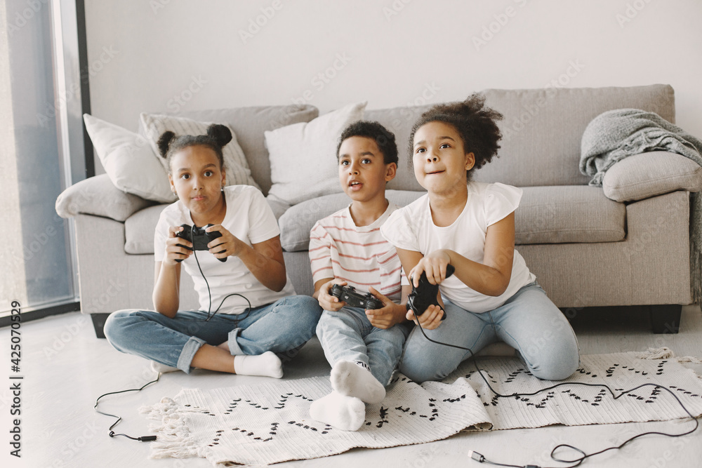 Wall mural Children play in video games at home on floor