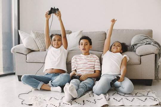 Children play in video games at home on floor