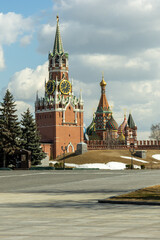 Spasskaya tower (Saviour Tower), Saint Basil's Cathedral, tree and cloudy sky. View from inside Kremlin