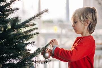 Jeune enfant d&eacute;core le sapin de no&euml;l