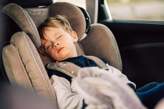 Enfant dort dans son si&egrave;ge auto.