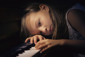 Dziewczyna w zadumie grająca na pianinie. - obrazy, fototapety, plakaty