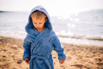 jeune enfant en peignoir sur la plage en été