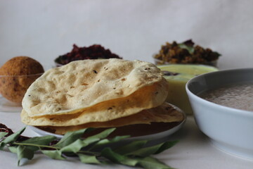 Papadum made with seasoned dough of peeled black gram flour, either fried or cooked with dry heat flipped over an open flame