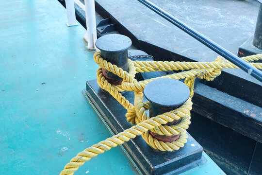 Closeup view of pair of metallic capstan in a ferry boat on Ganges, with yellow nylon ropes attached to it.
