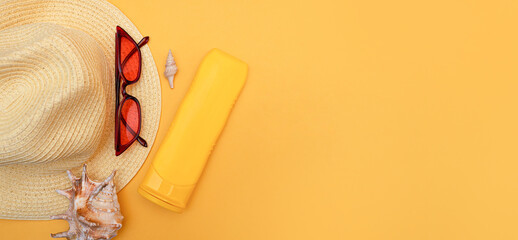 Women's straw hat, tanning cream, fashionable red sunglasses, seashells on a yellow background, copy space. Summer vacation concept. top view. Female accessory, summer background. Flat lay. Banner