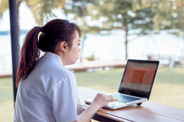 Asian woman working laptop. A woman working on a laptop at home