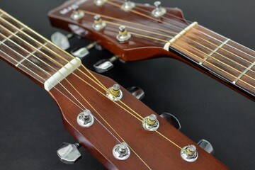 Two classical guitar fretboards side by side on a black background close up