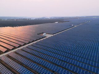 Aerial drone view into large solar panels at a solar farm at bright sunset. Solar cell power plants. © onphotoua