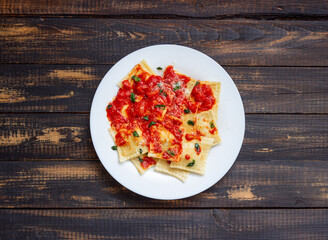Ravioli with tomato sauce, spinach and parmesan cheese. Healthy eating. Vegetarian food. Italian cuisine.