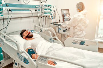A sick man for coronavirus disease covid-19, who lies in the intensive care unit in a modern...