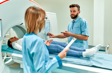 A patient lying on CT or MRI, the bed moves inside the machine, scanning her body and brain under...