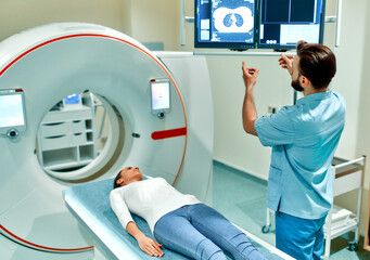 A patient lying on CT or MRI, the bed moves inside the machine, scanning her body and brain under...