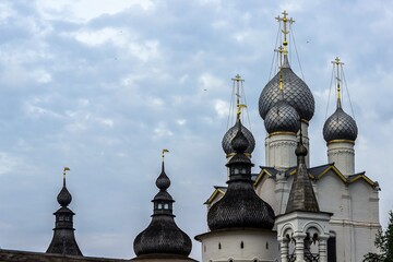 Fototapeta na wymiar Russia, Rostov, July 2020. Domes of the church and roofs of watchtowers.