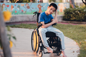 Obraz premium Asian special child on wheelchair is smiling face as happiness on the outdoor nature park background with parent in travel,Lifestyle in education age of disabled children,Happy disability kid concept.