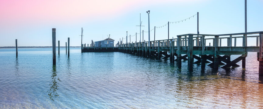 Panoramic Seascape with Long Pier and Pilings at Sunset in Hyannis Harbor in Massachusetts.