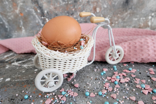 Chicken egg in a decorative basket
  light bike. Beautiful greeting card for Easter holiday, gray grunge background, concept greeting picture