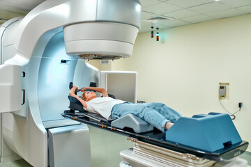 A young woman is undergoing radiation therapy for cancer in a modern cancer hospital. Cancer...