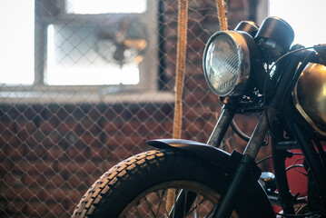 Old retro motorcycle in the old garage close up.