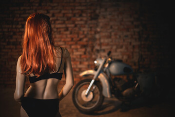 Female dummy in sunglasses on the old motorcycle background in the biker workshop concept.