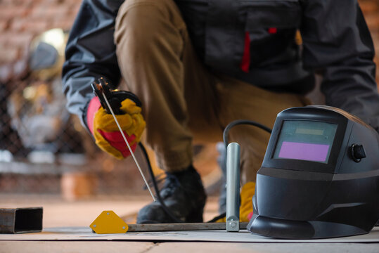 Welder is welding a metal frame close up.