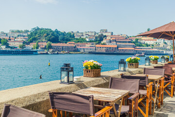 Cafe on the banks of the River Douro with a beautiful view in Porto, Portugal - obrazy, fototapety, plakaty