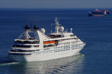Modern yacht cruise ship or cruiseship liner in the sun light against blue sea ocean and sky in...