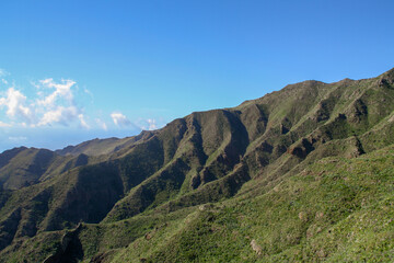 Fototapeta na wymiar Naturaleza en las colinas volcánicas del sur de la isla de Tenerife, Islas Canarias, España. Paisaje volcánico rocoso con montañas escarpadas y profundos barrancos.