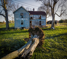 Abandoned country market building in rural Kentucky with eradicated tree in front of it