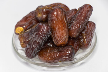 Dried dates fruit isolated on white background. Photo of Medina dates in a small plate.