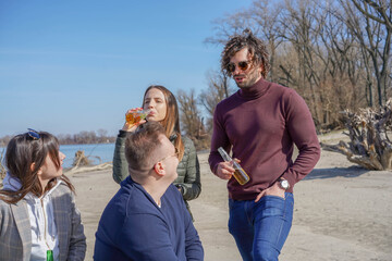 Happy people. Group of friends having good time at the beach. Weekend vibes. Drinking and talk jokes. Having great time at the sunny day.