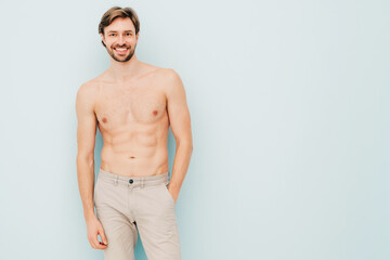 Portrait of sporty handsome strong man. Healthy smiling athletic fitness model posing near light...
