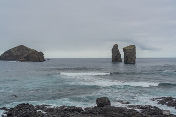 Mosteiros beach, volcanic sand beach in Sao Miguel, Azores, background the ilhéus islands