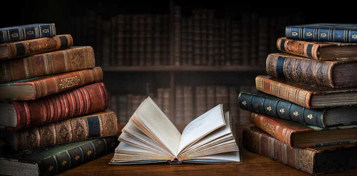 Old books on wooden desk in old library. Ancient books historical background. Conceptual background on history, education, literature topics..