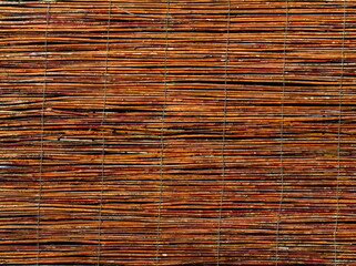 Fence made of wood, thin wooden sticks tied together with metal wire, wooden cover, twigs fence