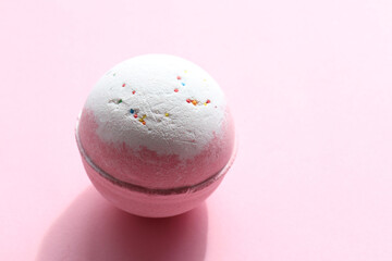 DIY Birthday Cake Bubble Bath Bomb with sprinkles on pink background. Pink salt bomb on colored pastel backdrop. Top view, copy space. Natural beauty spa body care product

