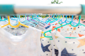 Fototapeta na wymiar Baby Clothing on a clothesline. Dry clothes in bright colors in the sun. Clothesline with hanging baby clothes.