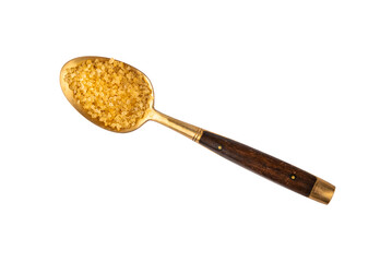 Vintage golden spoon full of brown cane sugar