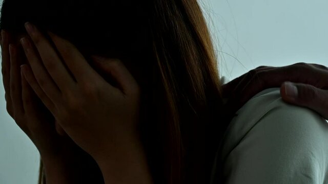 A man comforts a girl friend who is sad and lonely in the bedroom