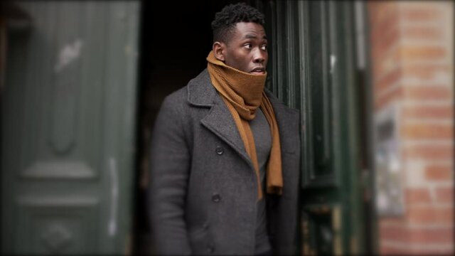 African man leaves home in the morning during winter season, elegant person steps out