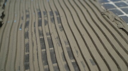Laying ceramic floor tiles, applying an adhesive base. Application of a solution for laying tiles on the floor.