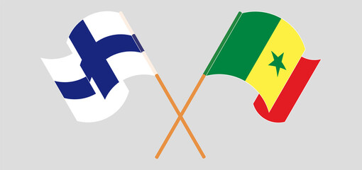 Crossed and waving flags of Finland and Senegal