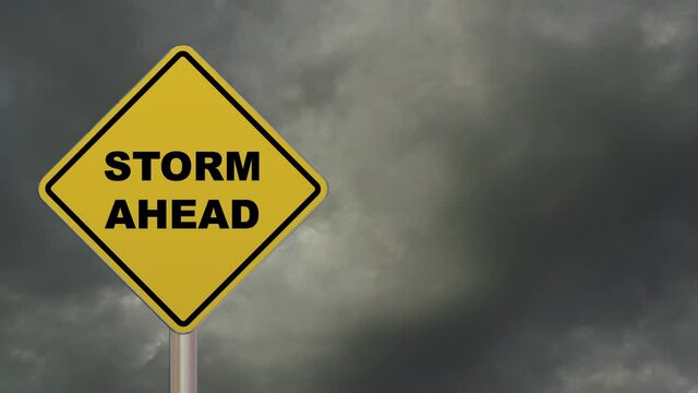 Time lapse of a diamond-shaped crossing sign with yellow background and black border with a short phrase saying “Storm Ahead” in the middle.