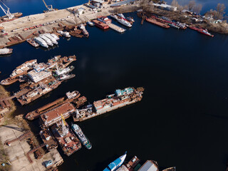 Aerial view of moored old barges and ships in river port