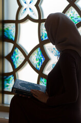 A young Muslim woman reads the Quran in the mosque during the holy month of Ramadan