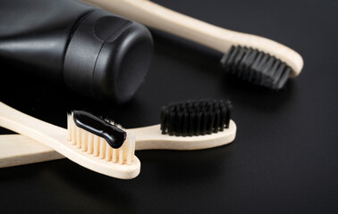 Group eco bamboo toothbrushes, on black background. Top view, copy space.